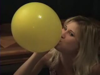 lexi blows up a yellow balloon until it pops