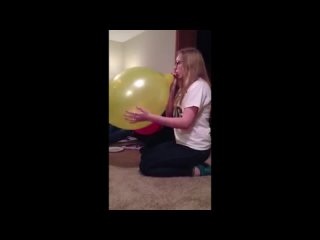 girl blow to pops large yellow punch balloon getting dizzy