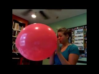 girl blows up a giant punch balloon takes it outside to pop